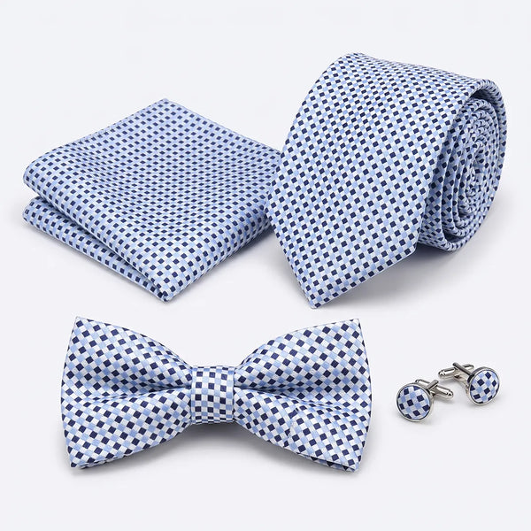 Flat lay of a Sailor Australia light blue and navy micro-check 4-piece tie set including a tie, pocket square, bow tie, and cufflinks.