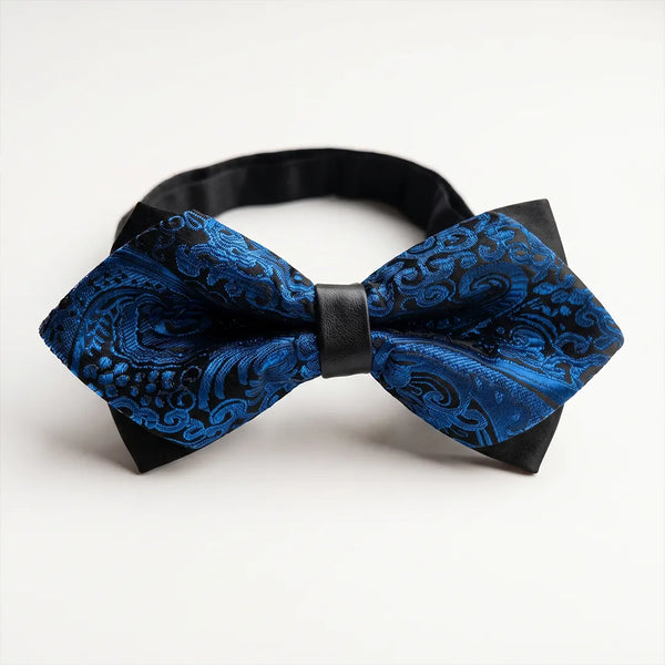 Close-up of a royal blue and black paisley jacquard diamond bow tie featuring sharp pointed edges and a solid black center knot on a smooth polyester fabric.