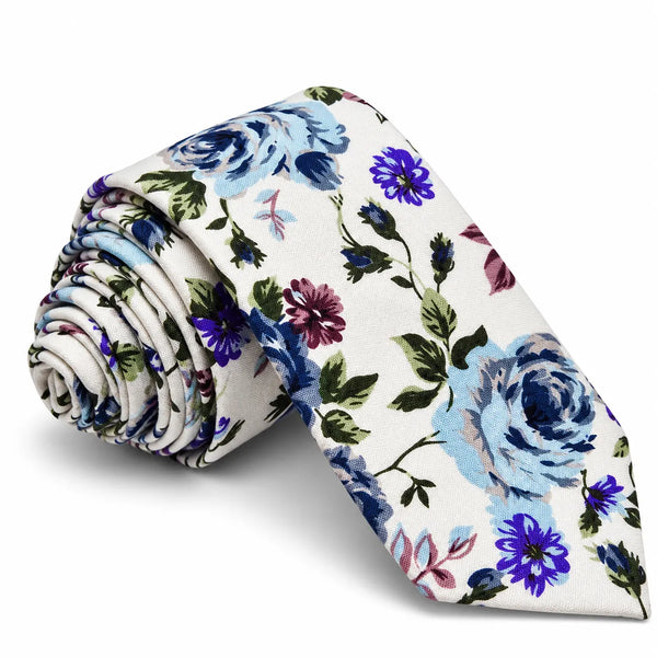 A rolled-up necktie featuring a watercolor floral pattern with light blue, purple, and pink flowers on an off-white background, displayed on a clean white studio background.