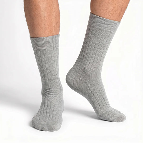 Close-up of a man's feet wearing light heather grey ribbed crew socks.
