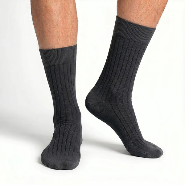 Close-up of a man's feet wearing dark charcoal grey ribbed crew socks.