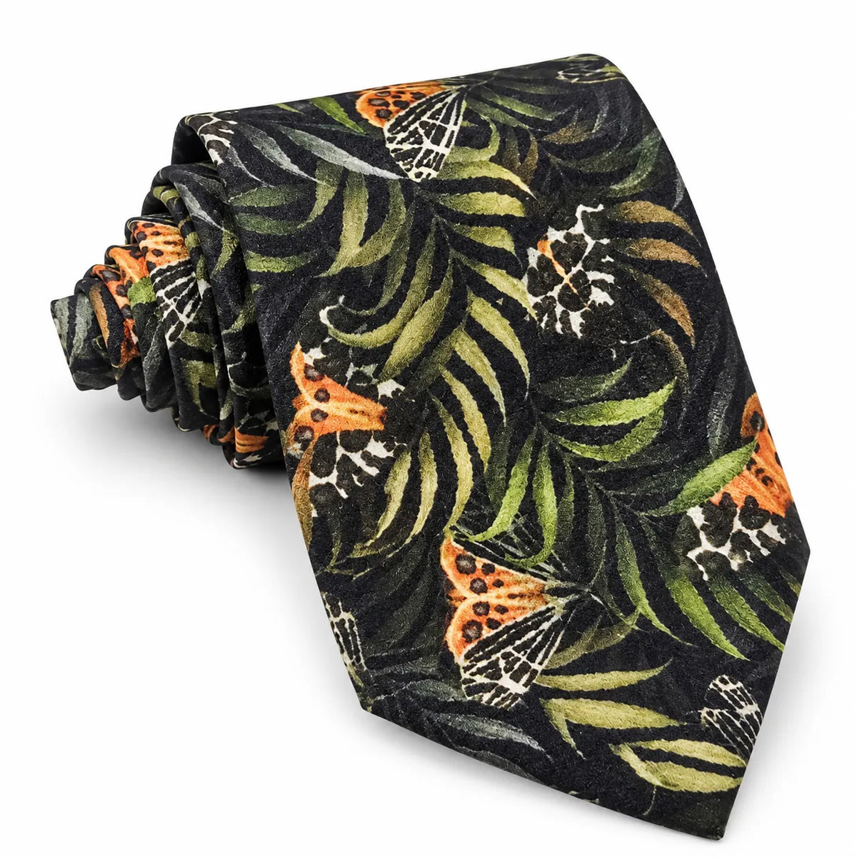 A rolled necktie featuring a tropical pattern with green palm leaves, orange butterflies, and white spider silhouettes on a black background, set against a plain white studio backdrop.
