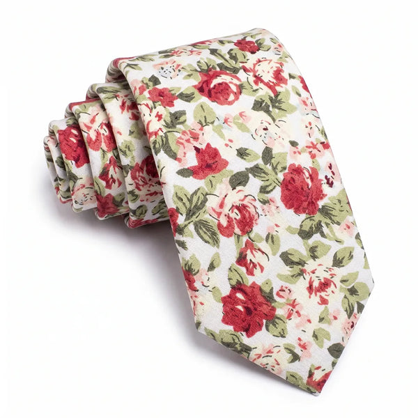 Close-up of a rolled white cotton necktie featuring a large-scale red rose floral pattern with green foliage.