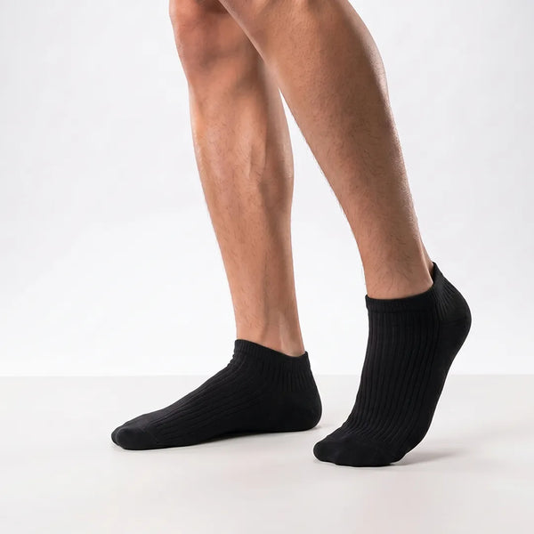 Close-up of a man's feet wearing black ribbed low-cut ankle socks.