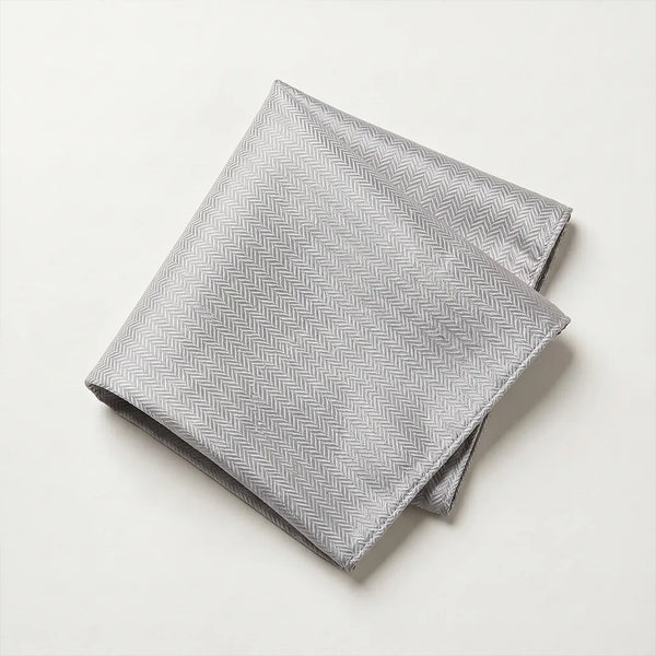 Close-up of a folded silver-grey herringbone jacquard polyester pocket square.