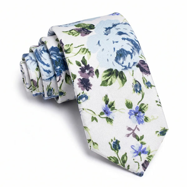 Close-up of a rolled white cotton necktie featuring a painterly floral pattern in light blue, violet, and green.
