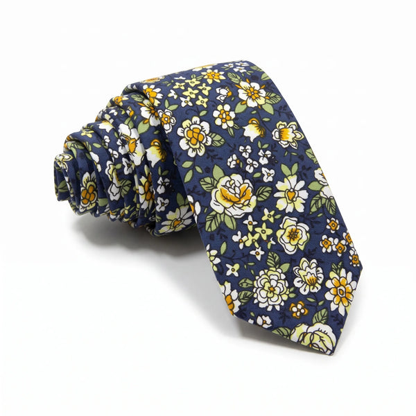 A navy blue necktie with a dense floral pattern of white, yellow, and light green flowers, rolled on a white background.