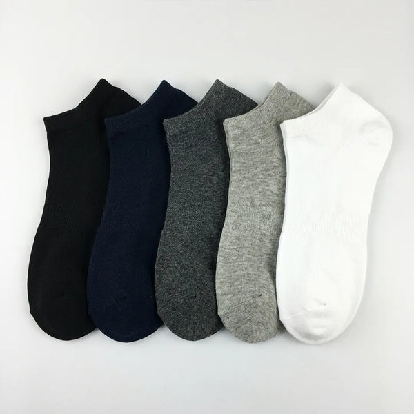 Flat lay of a 5-pack of men's solid ankle socks in black, navy blue, dark grey, light grey, and white.