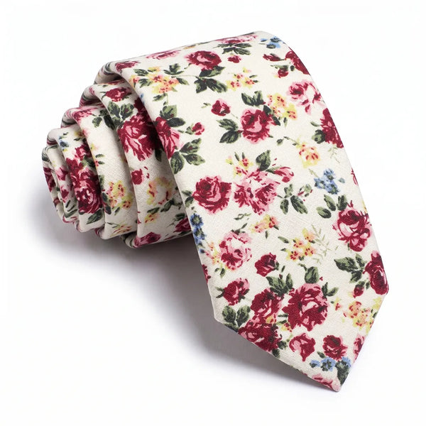 Close-up of a rolled cream cotton necktie featuring a vintage ditsy floral pattern in burgundy, yellow, and blue.