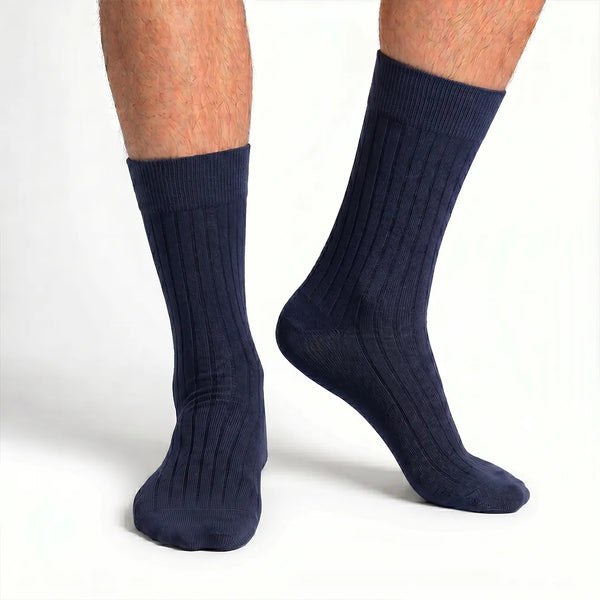 Close-up of a man's feet wearing dark navy blue ribbed crew socks.