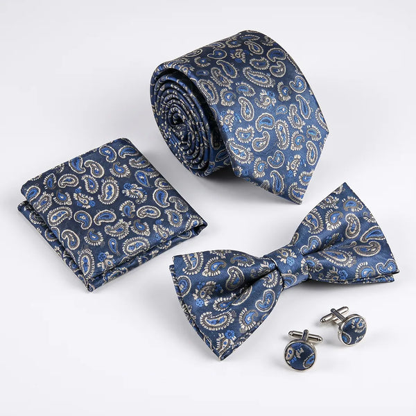 Flat lay of a Sailor Australia blue and silver paisley 4-piece tie set including a tie, pocket square, bow tie, and cufflinks.
