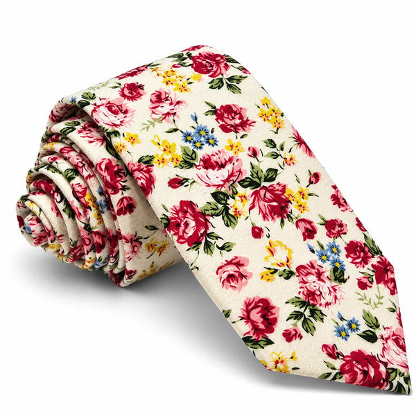 A rolled-up necktie with a vintage floral print on a cream background, featuring red, pink, yellow, and blue flowers with green leaves, set against a plain white background.