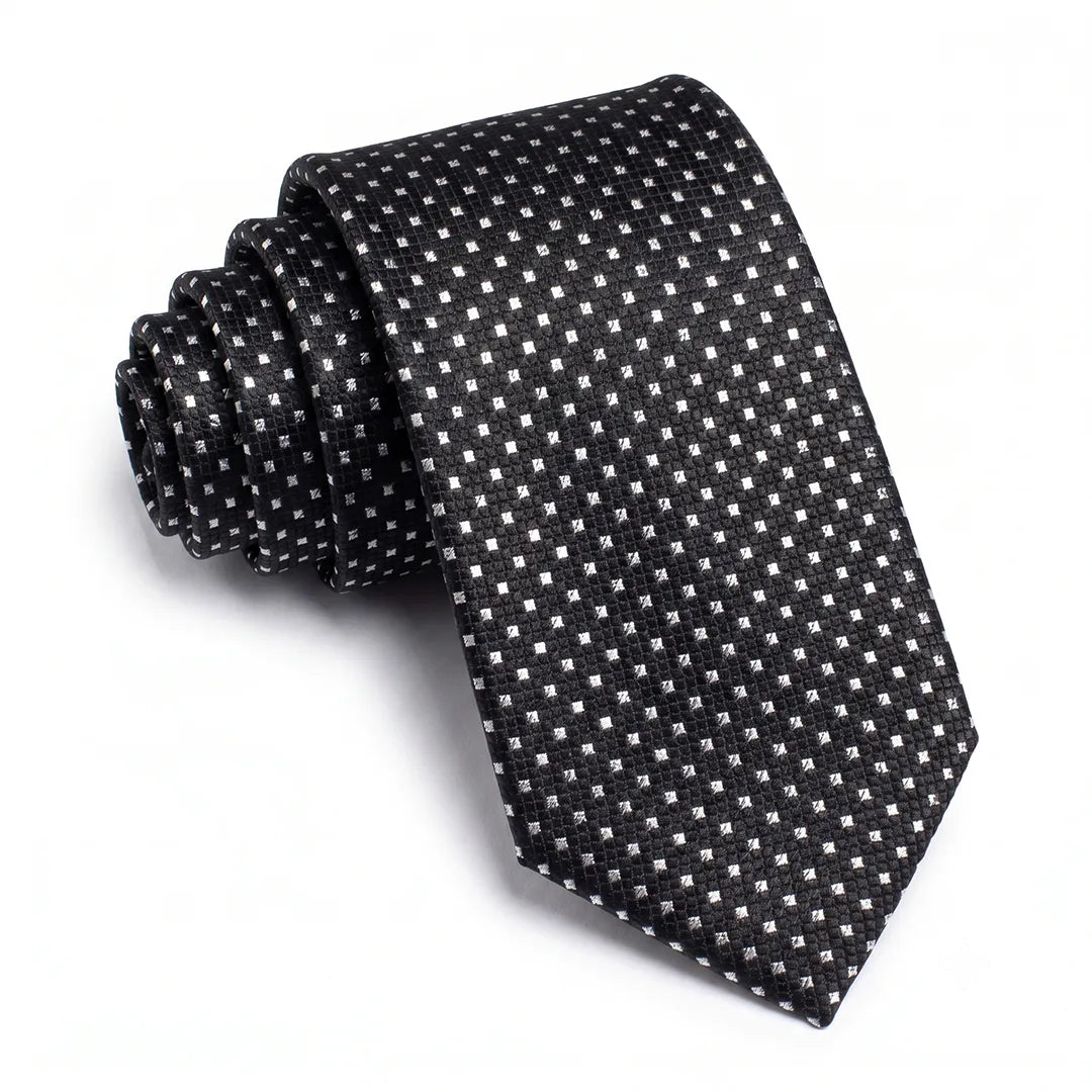 Close-up of a black skinny tie featuring a textured silver micro-dot pattern on a smooth polyester fabric.