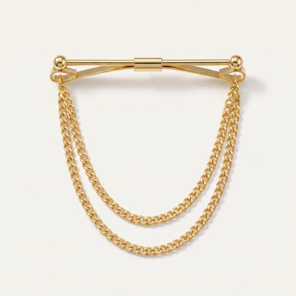 Close-up of a polished gold-tone horizontal collar pin with spherical ball ends and two tiered, draped curb chains.