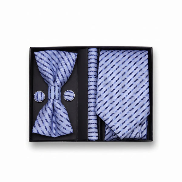 A men's formal accessory gift set in a black presentation box, featuring a light blue and navy patterned bow tie, matching necktie, pocket square, and round buttons.