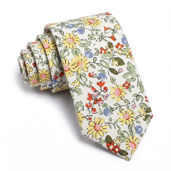 Close-up of a rolled beige cotton necktie featuring a botanical floral pattern in yellow, blue, and red-orange.