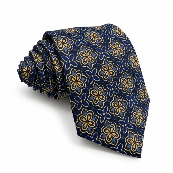 Rolled navy blue necktie featuring an all-over gold and royal blue geometric floral medallion pattern on a white background   