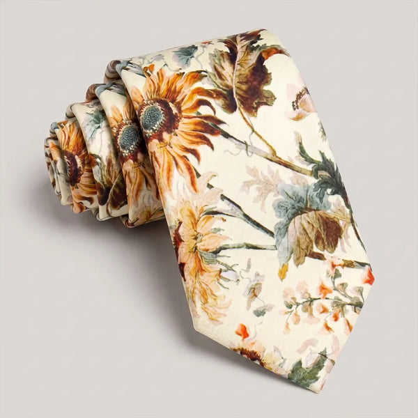Close-up of a cream ivory floral silk tie featuring large sunflowers and sage green botanical patterns.