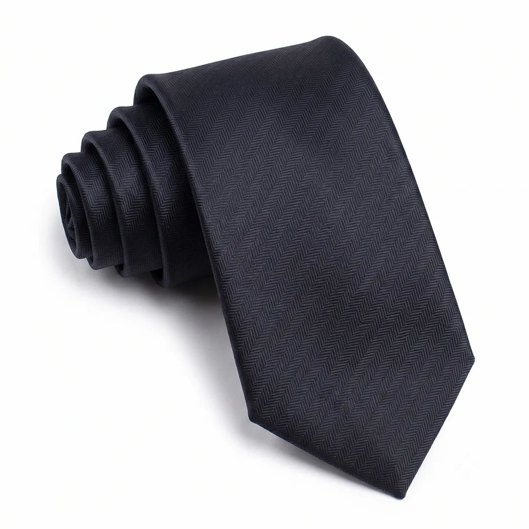 Close-up of a black skinny tie featuring a textured herringbone chevron weave on a smooth polyester fabric.