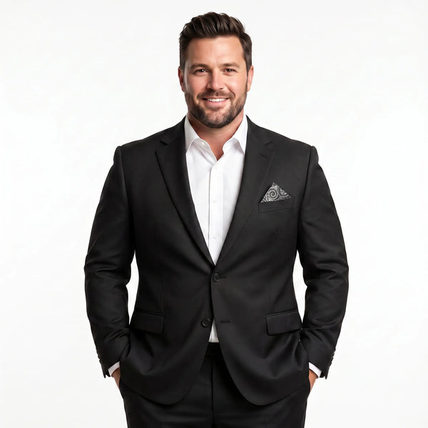 Bearded man wearing an oversized black 2-piece suit with a white shirt and patterned pocket square.