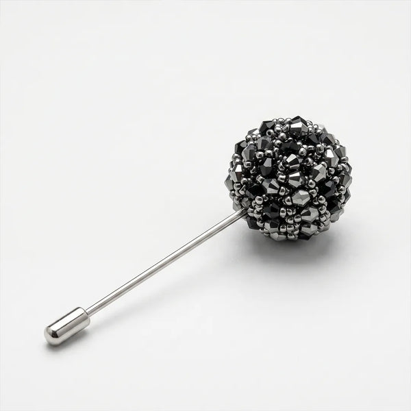 Close-up of a black and silver faceted beaded lapel pin with a silver metal stem and end cap.