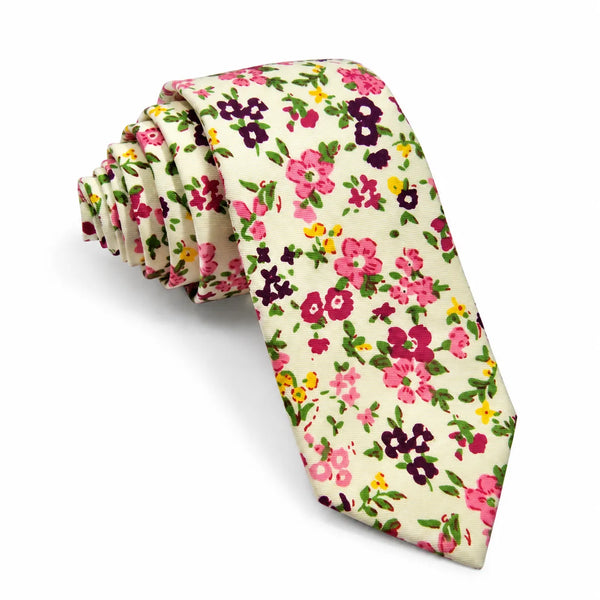Rolled cream cotton slim necktie featuring an all-over ditsy floral print in berry pink, plum purple, and yellow on a white background