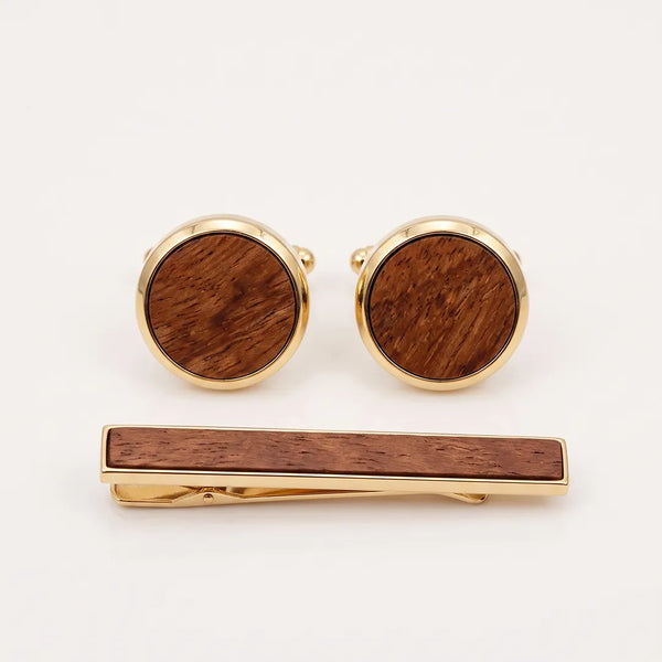 Close-up flat lay of a round gold-tone cufflink and tie clip set featuring a natural brown wood inlay.