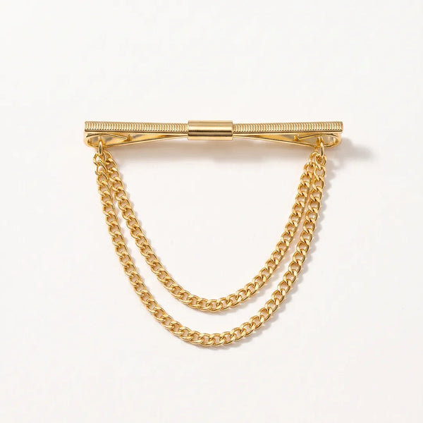 Close-up of a polished gold-tone horizontal collar pin with two tiered, draped curb chains hanging below.