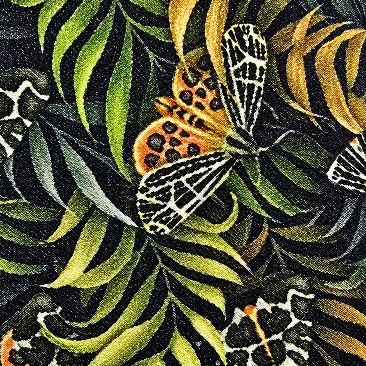 A close-up of a tropical fabric or wallpaper pattern featuring a black background with large green and yellow leaves and a central orange butterfly with black spots and white wing patterns.