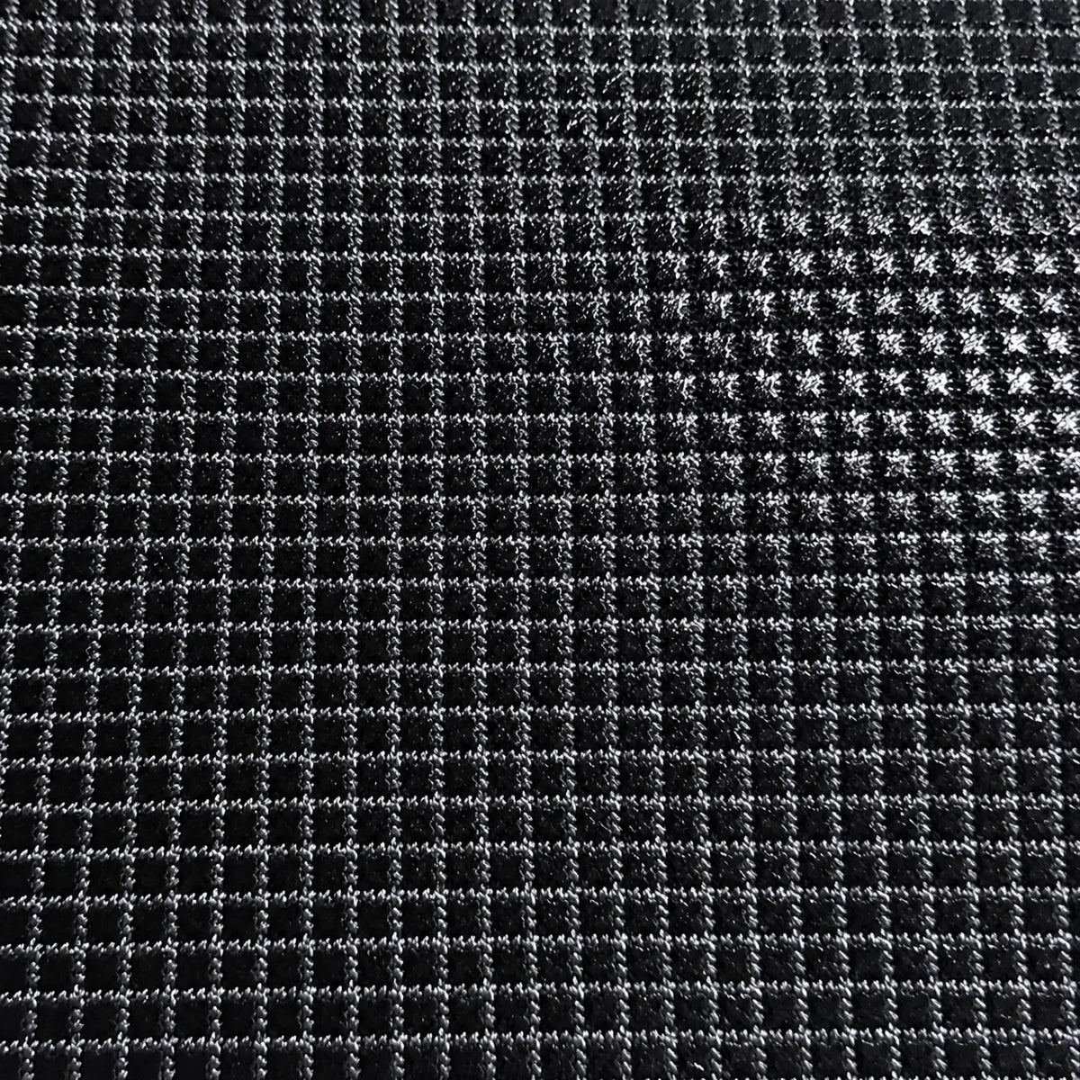 Close-up of a black mesh screen fabric with a grid pattern and small star-like cutouts on the right side.