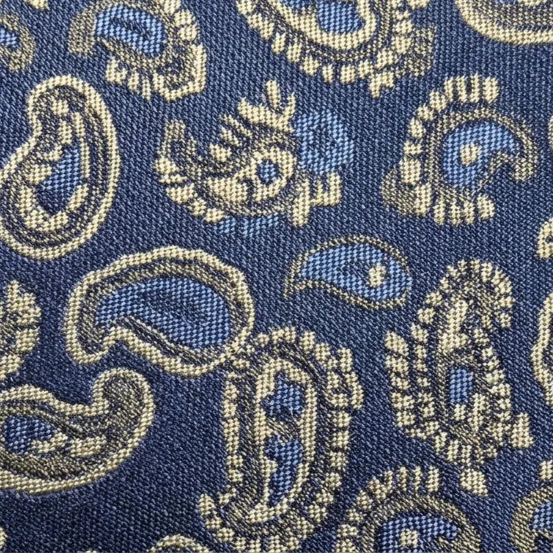 A close-up of a woven fabric with a classic paisley pattern in navy blue, light blue, and beige.