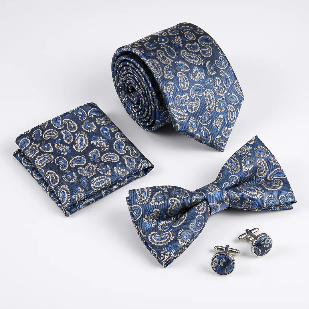 A men's formal accessory set featuring a blue paisley patterned necktie, matching pocket square, bow tie, and cufflinks, arranged on a clean white background.
