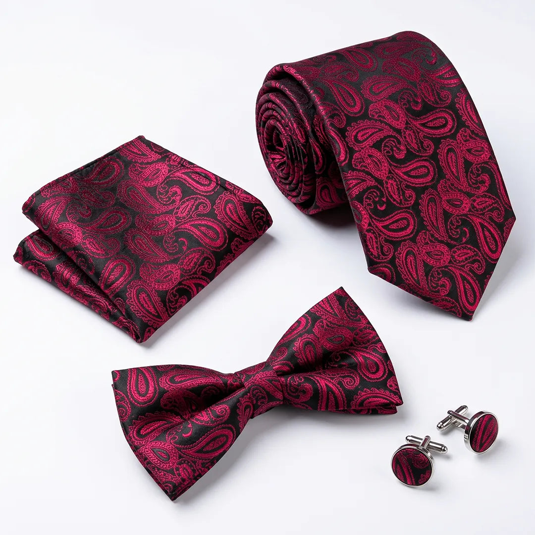 A men's formal accessory set featuring a paisley patterned necktie, matching pocket square, bow tie, and round cufflinks, all in a deep red and black design on a clean white background.