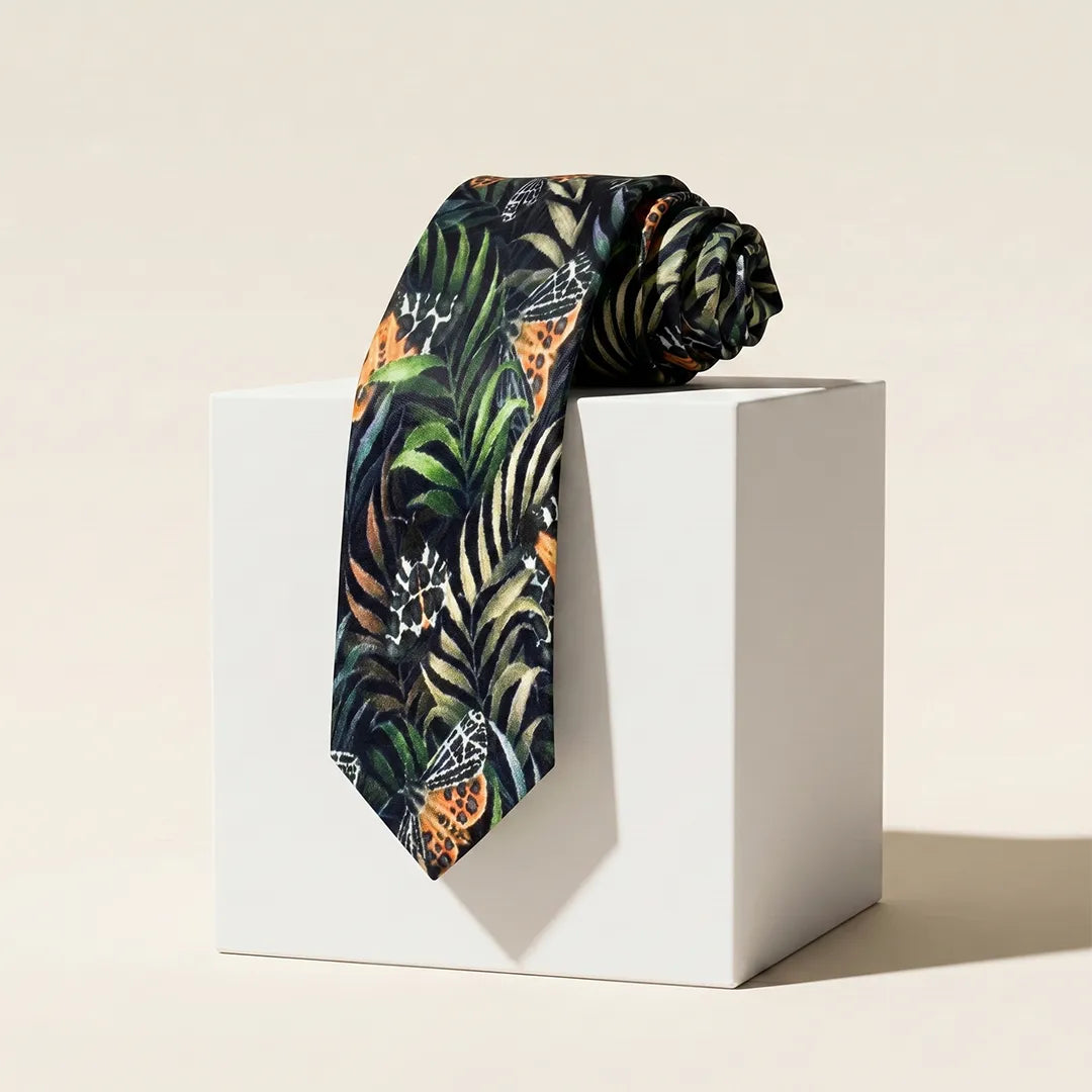 Tropical patterned tie on a white pedestal against a beige background