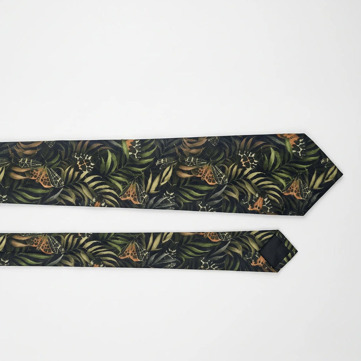 Two views of a necktie with a tropical leaf and butterfly pattern on a white background.